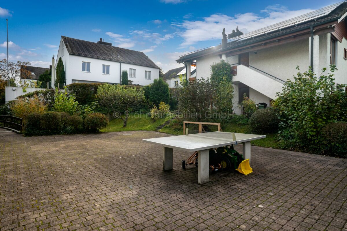 Gepflasterter Innenhof mit Wohnhäusern und Tischtennisplatte