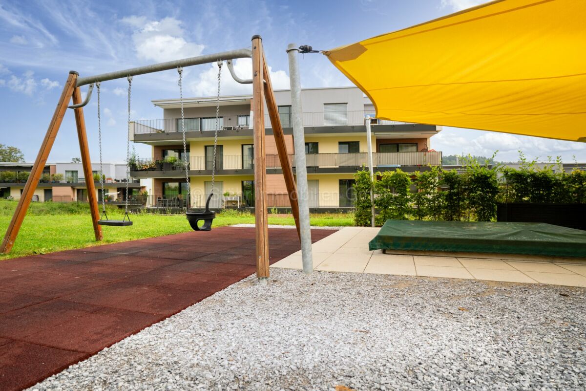 Außenbereich mit Spielplatz und Mehrfamilienhaus