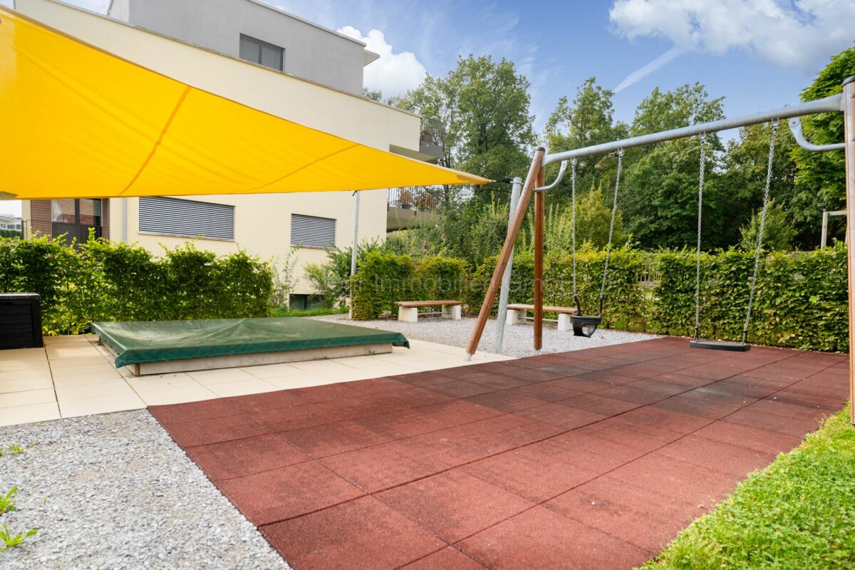 Außenbereich mit Sonnensegel und Spielplatz