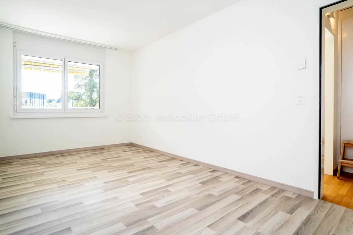 Heller leerer Raum mit Fenster und offener Tür