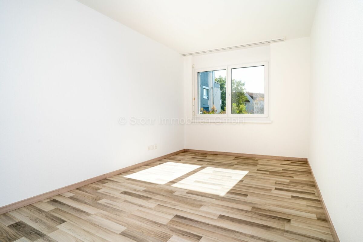 Heller leerer Raum mit Holzoptikboden und Fenster