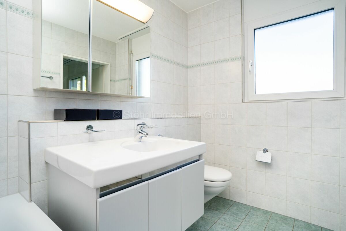 Helles Badezimmer mit Waschtisch und Fenster
