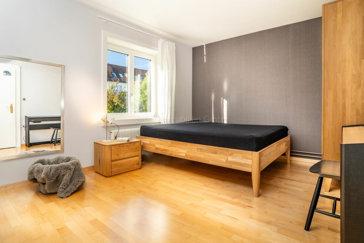 Helles Schlafzimmer mit Holzbett und Fensterblick