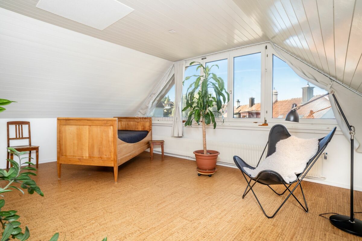 Helles Dachgeschosszimmer mit Bett und Sitzbereich