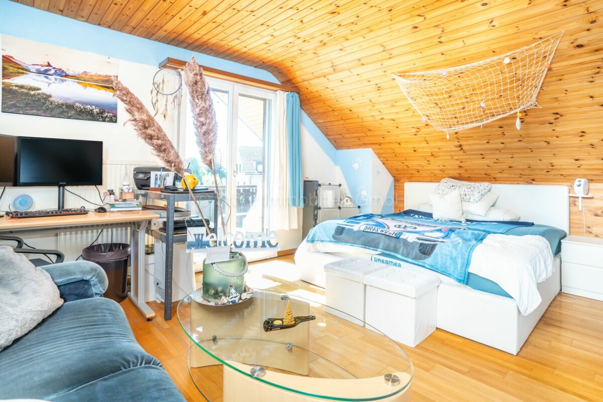 Gemütliches Dachzimmer mit Schlafbereich und Homeoffice-Ecke