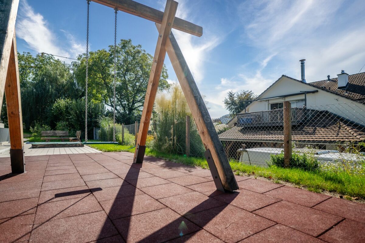 Garten mit Spielbereich und Nachbarhaus