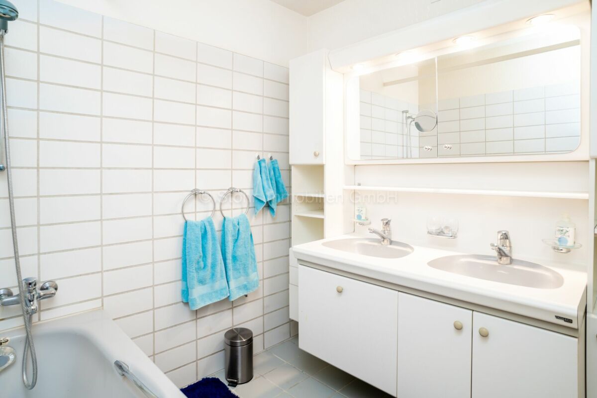 Helles Badezimmer mit Doppelwaschbecken und Badewanne