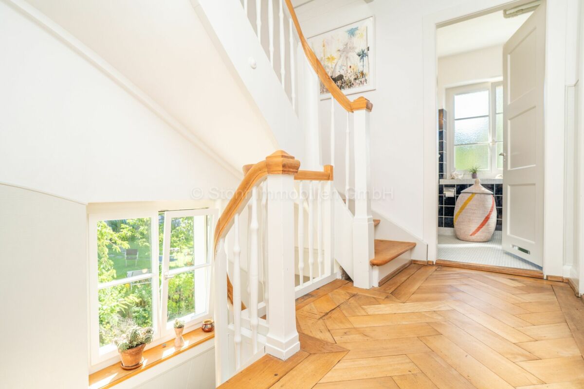 Heller Flur mit Holztreppe
