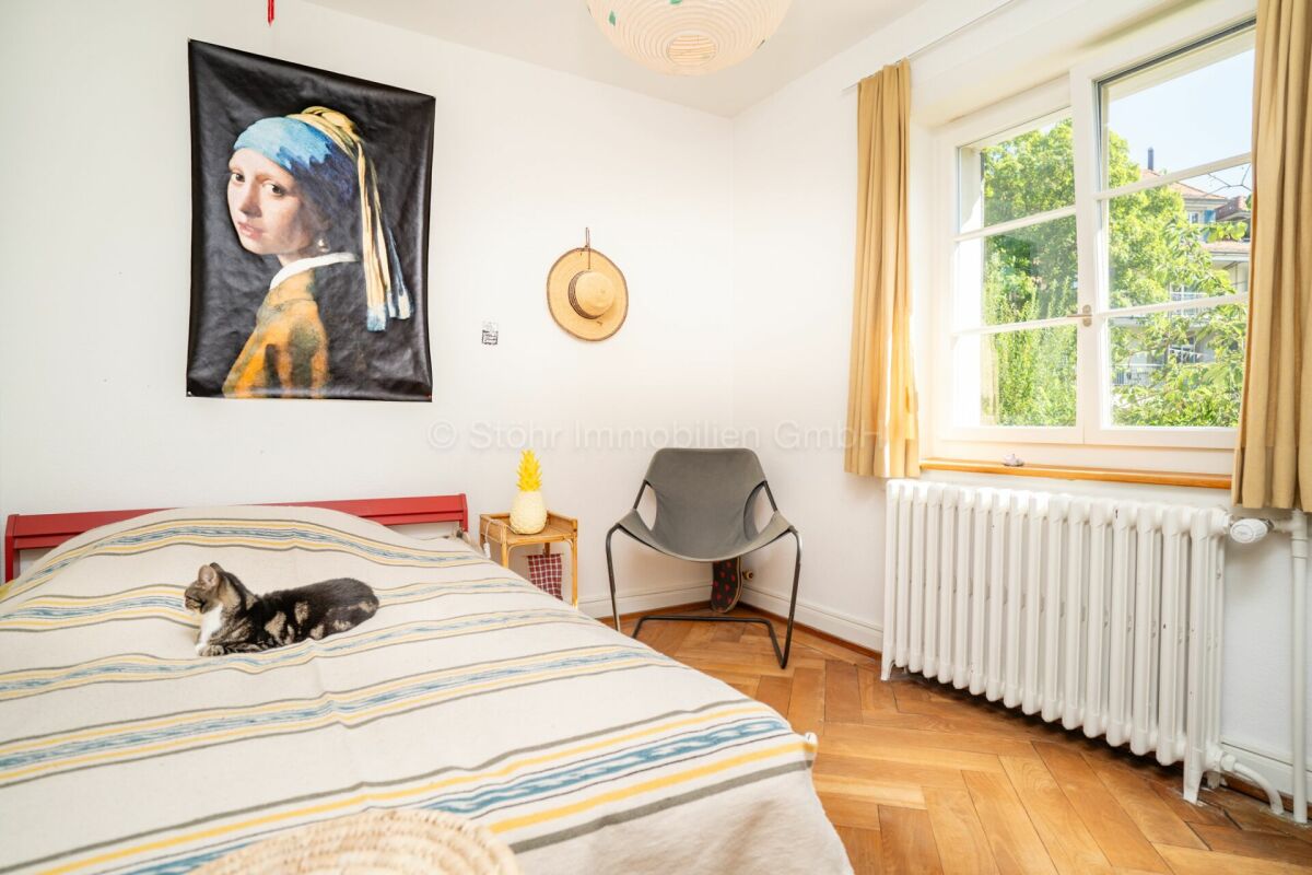 Helles Schlafzimmer mit klassischem Fenster und Holzparkett