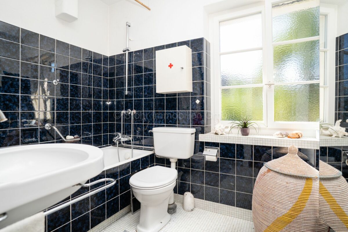 Badezimmer mit dunkler Kachelverkleidung
