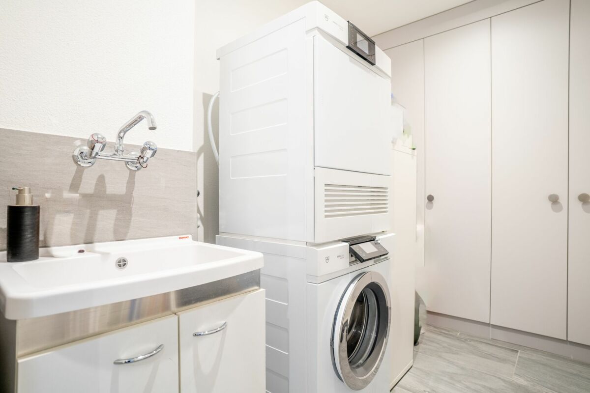 Hauswirtschaftsraum mit Waschmaschine und Waschbecken