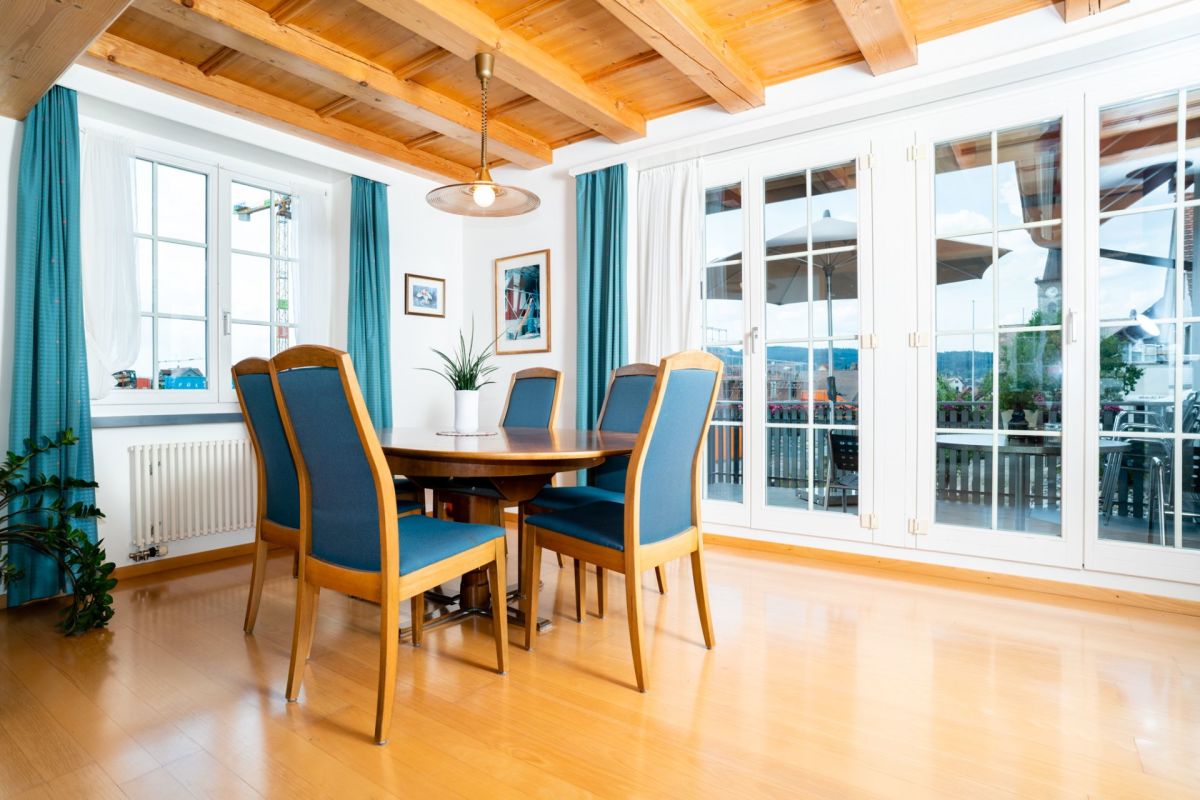 Esszimmer mit Holzdecke und großen Fenstertüren