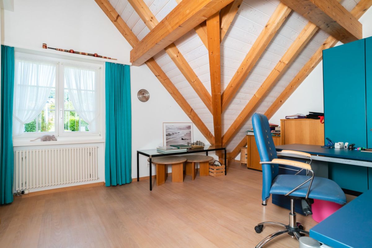 Dachgeschoss-Arbeitszimmer mit sichtbaren Holzbalken