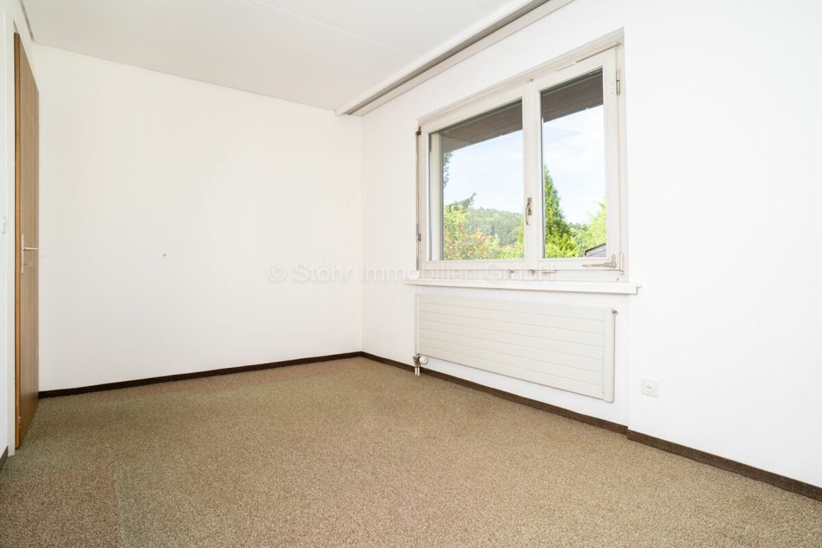 Helles leeres Zimmer mit Fenster und Heizkörper