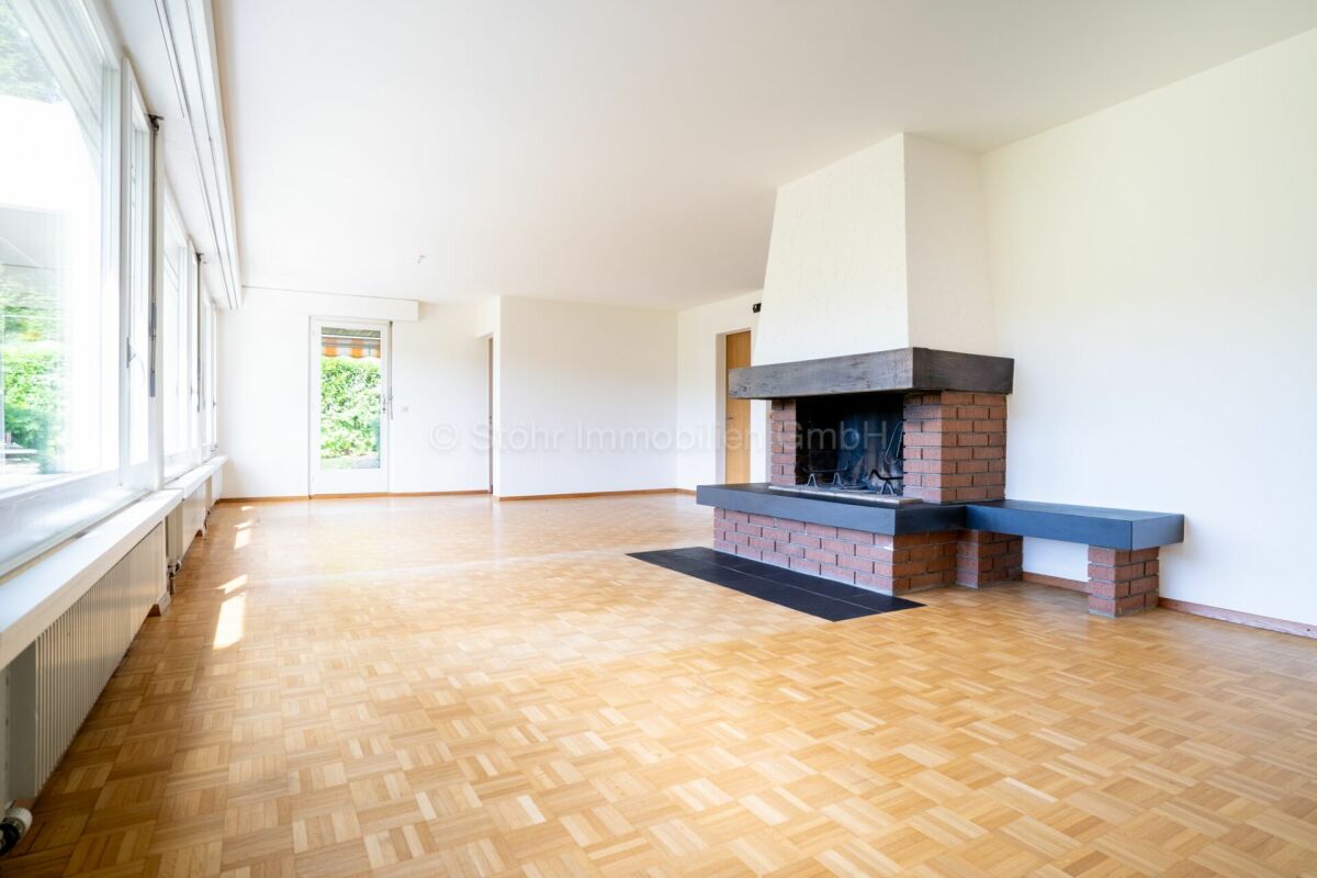 Heller Wohnraum mit Kamin und großer Fensterfront