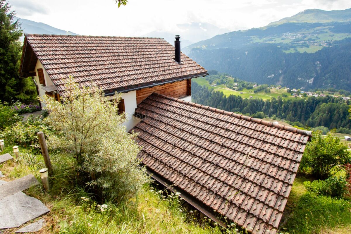 Berghaus mit Steildächern und Alpenpanorama