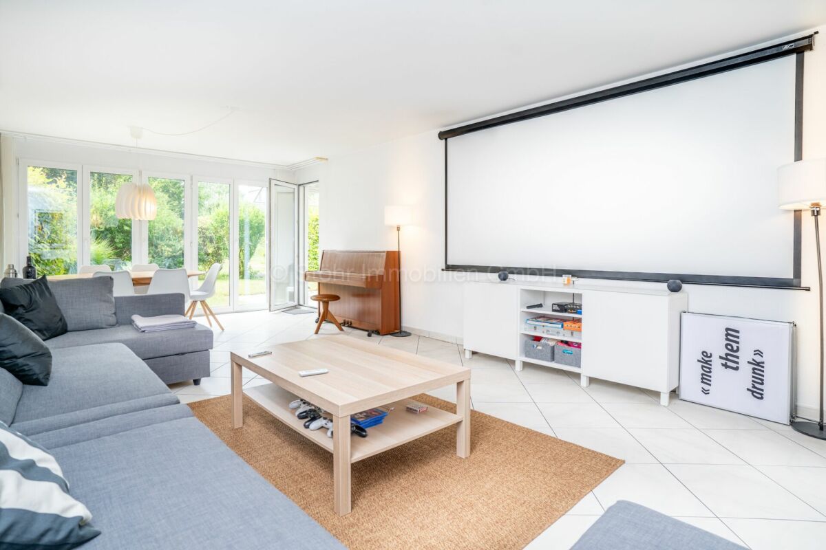 Helles Wohnzimmer mit Essbereich und Projektorwand