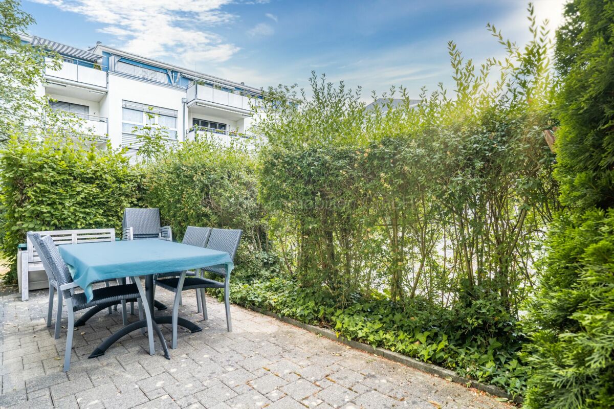 Terrasse mit Gartenmöbeln und viel Grün