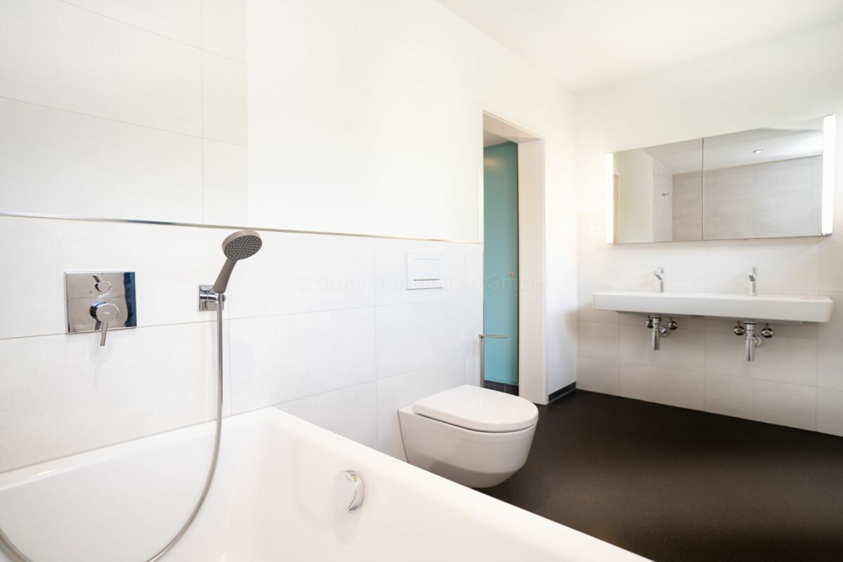 Modernes Badezimmer mit Badewanne, WC und Doppelwaschtisch