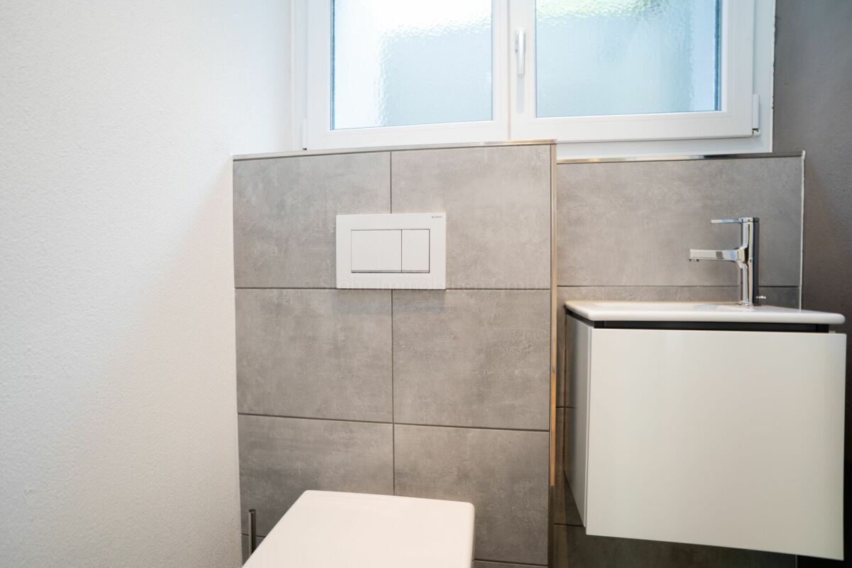 Modernes Bad mit Fenster und wandhängendem WC