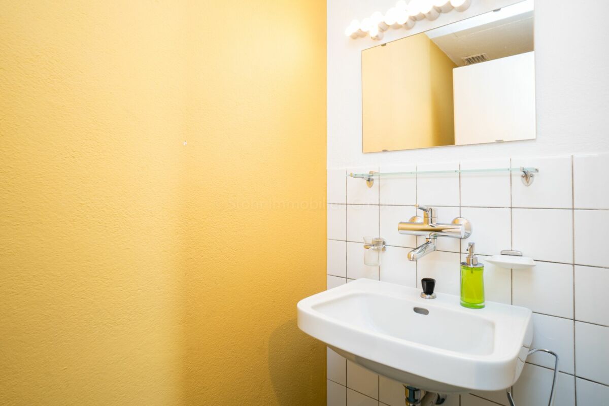 Gäste-WC mit Waschbecken und Spiegel