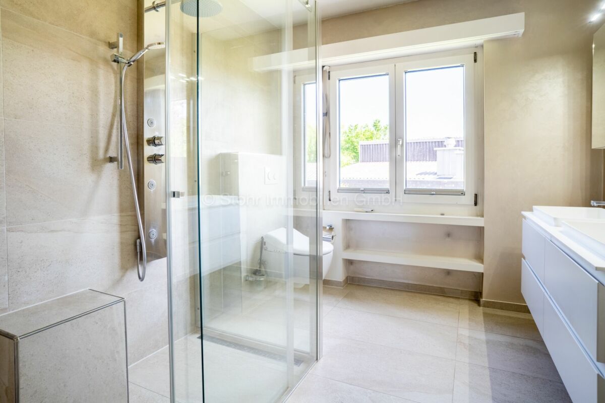 Modernes Badezimmer mit Glasdusche und Fenster
