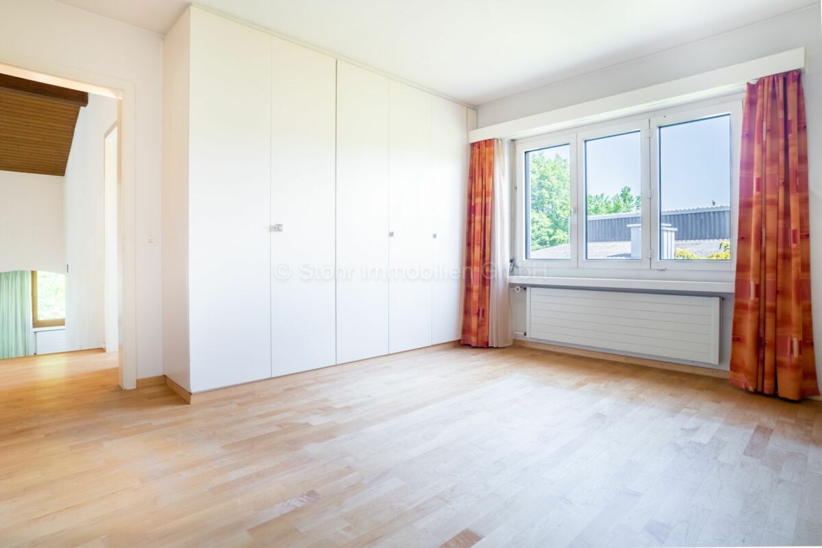 Helles Schlafzimmer mit Einbauschrank und großem Fenster