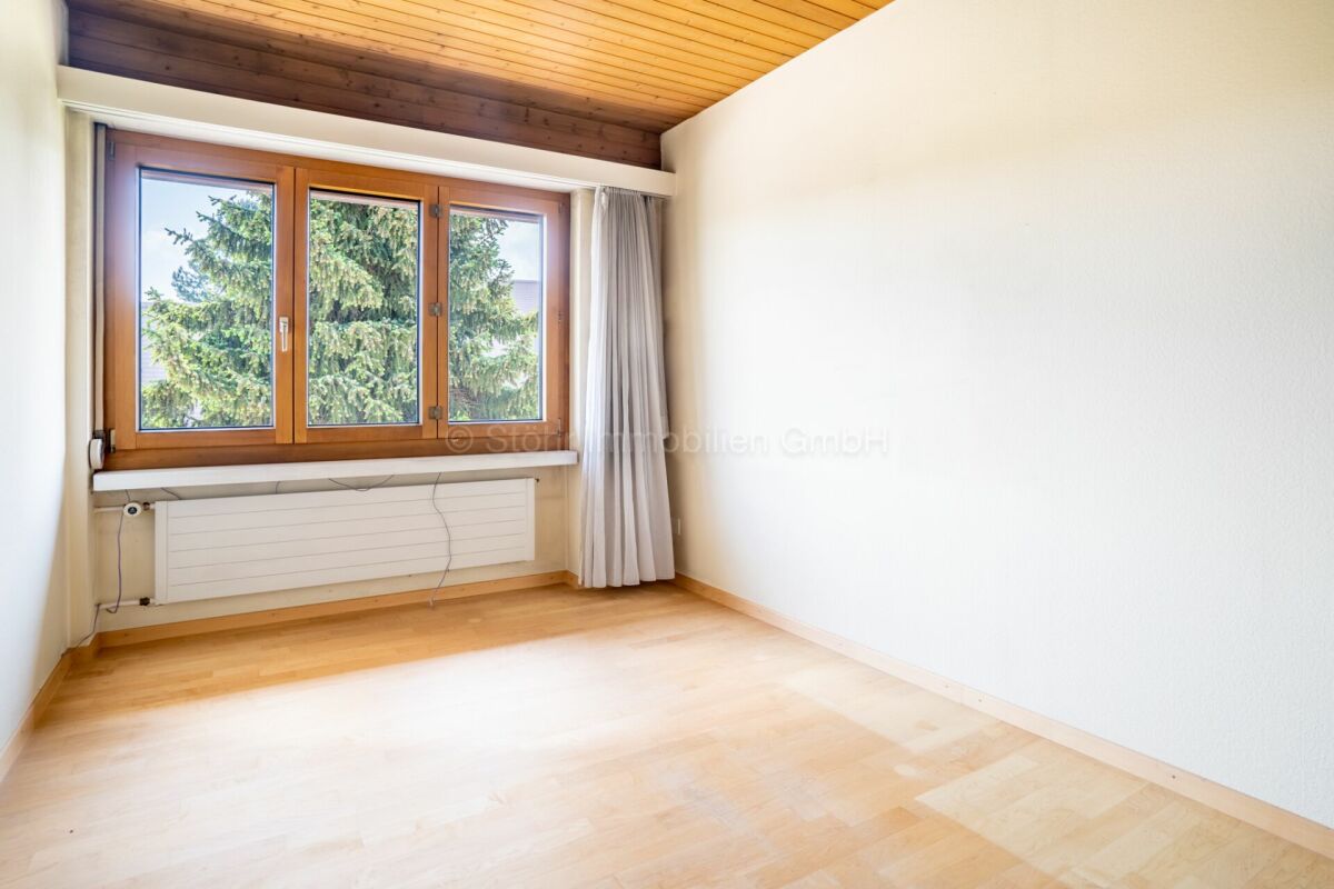 Heller leerer Raum mit Holzdecke und Fenster