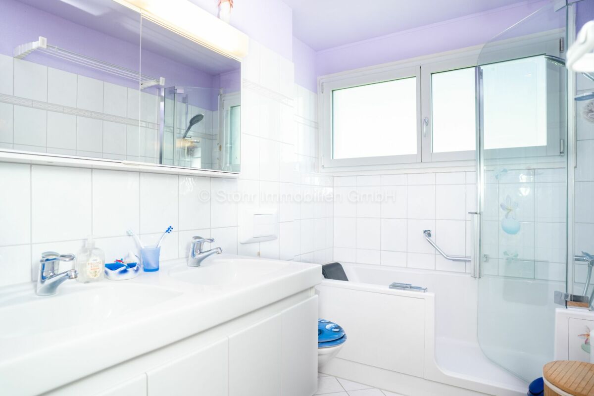Helles Badezimmer mit Badewanne und Duschkabine