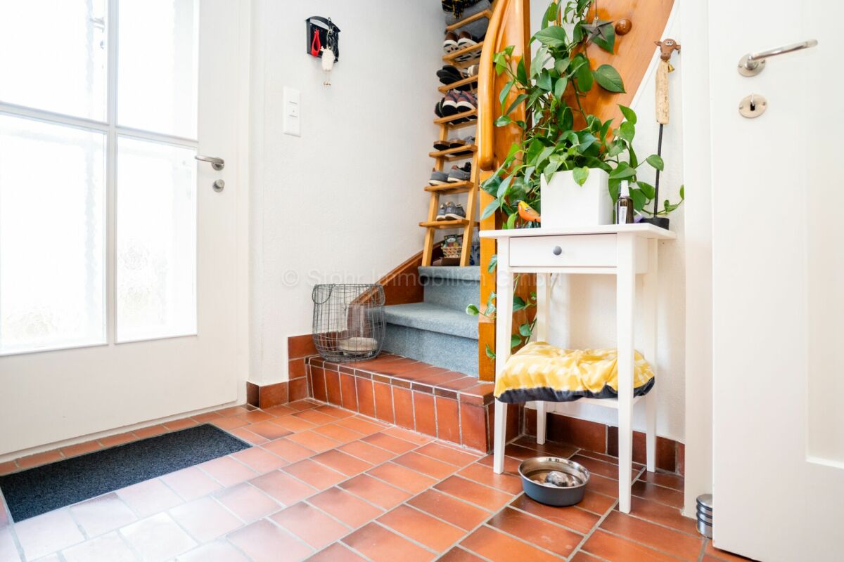 Flur mit Terrakottafliesen und Treppe