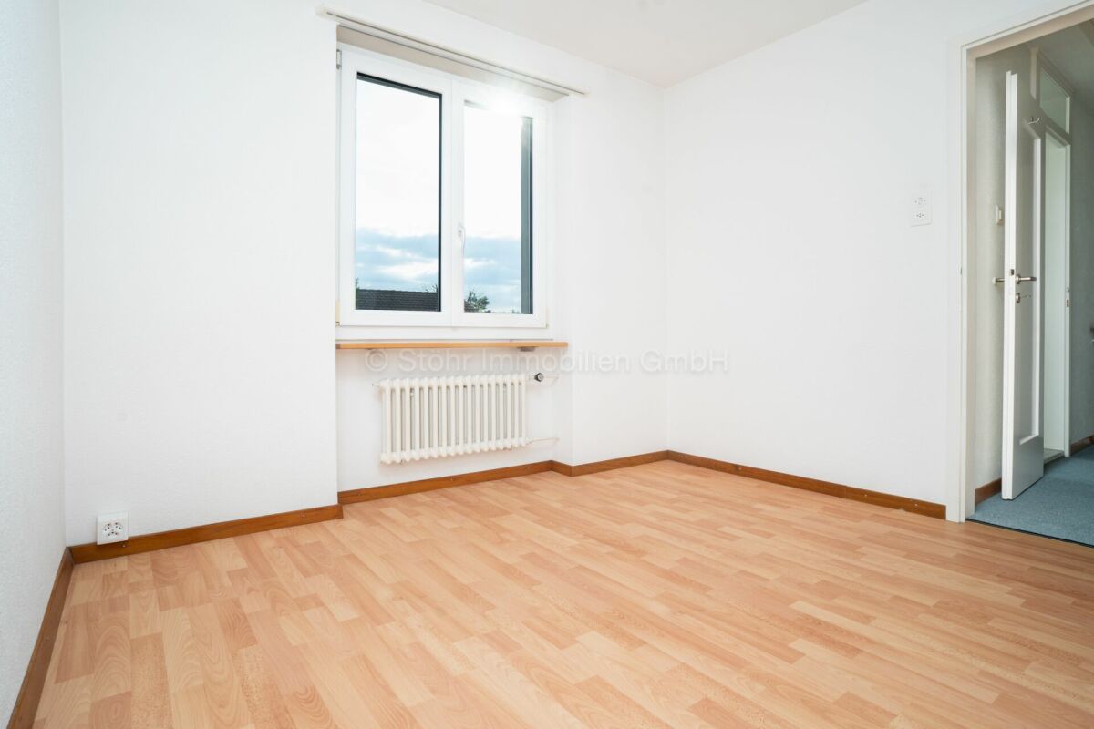 Leerer heller Raum mit Fenster und Heizkörper