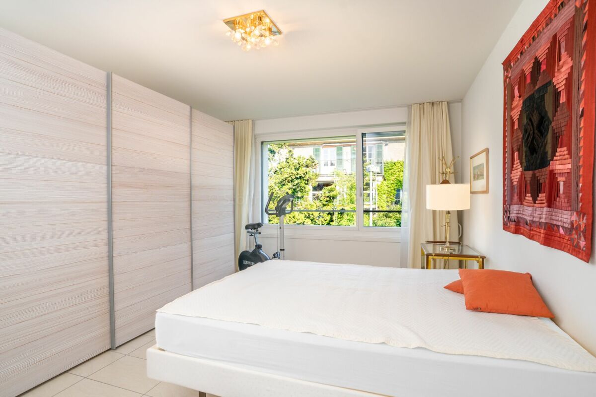 Helles Schlafzimmer mit großem Fenster und Einbauschrank