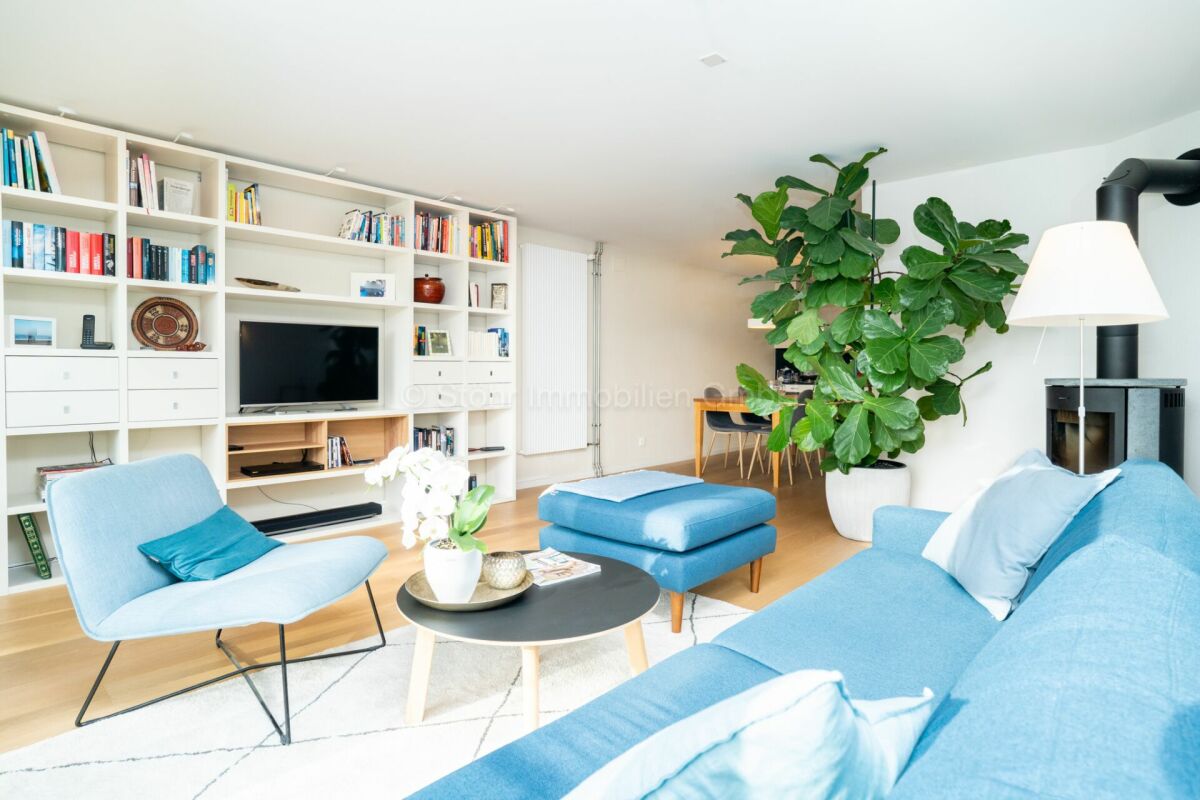 Helles Wohnzimmer mit Bibliothekswand und Ofen
