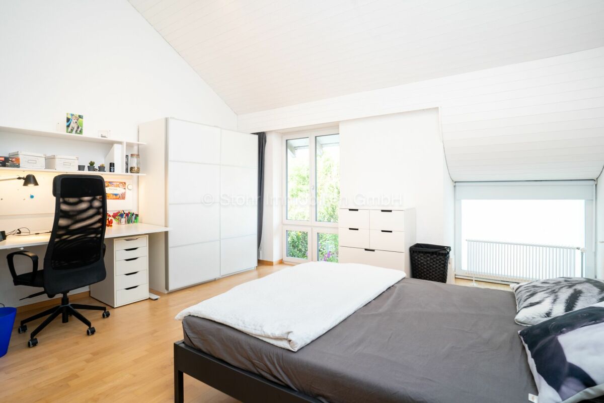 Helles Schlafzimmer mit Arbeitsbereich und Dachschräge