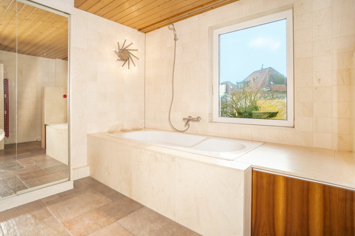 Badezimmer mit Badewanne und Fenster