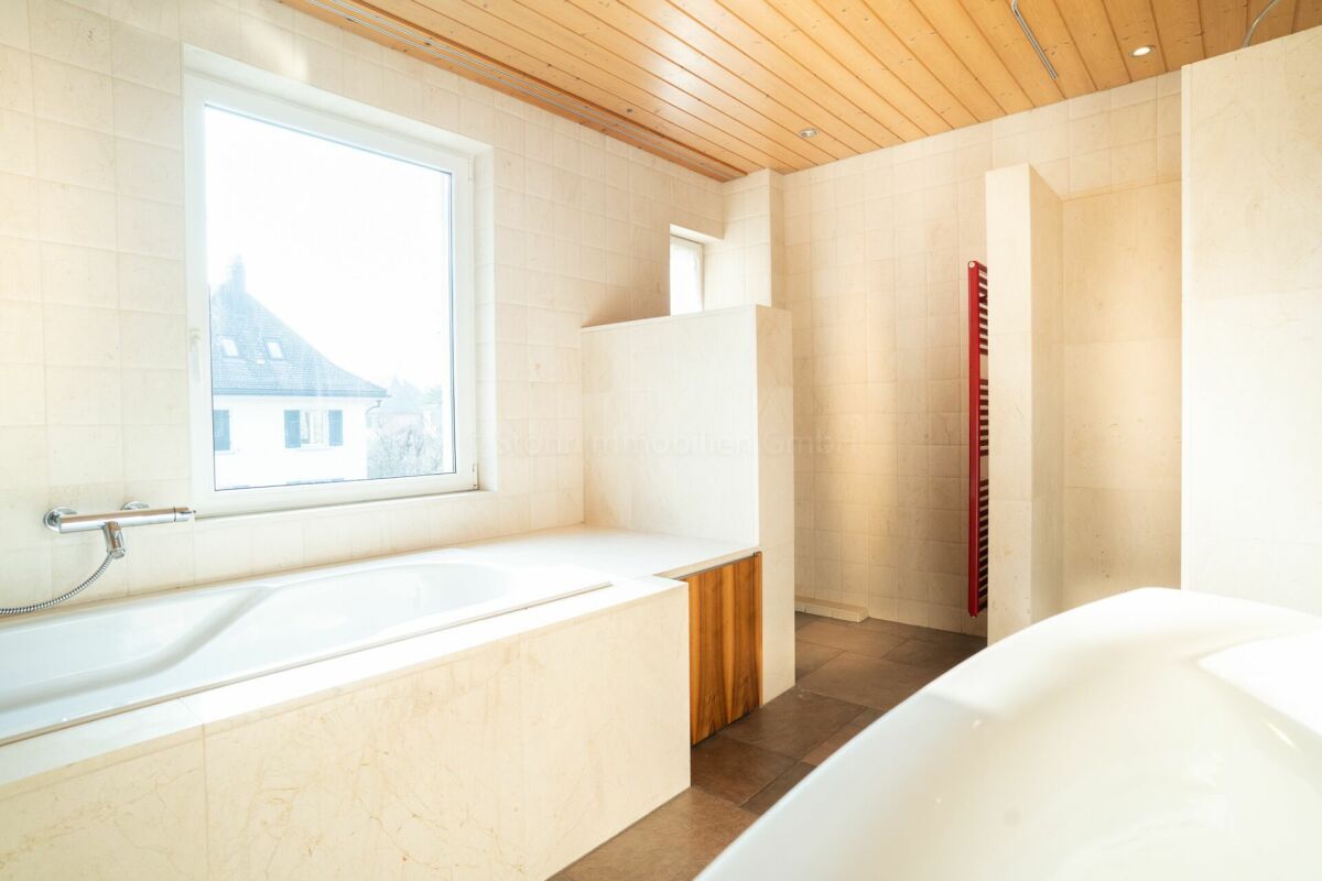 Modernes Badezimmer mit Badewanne und Holzdecke