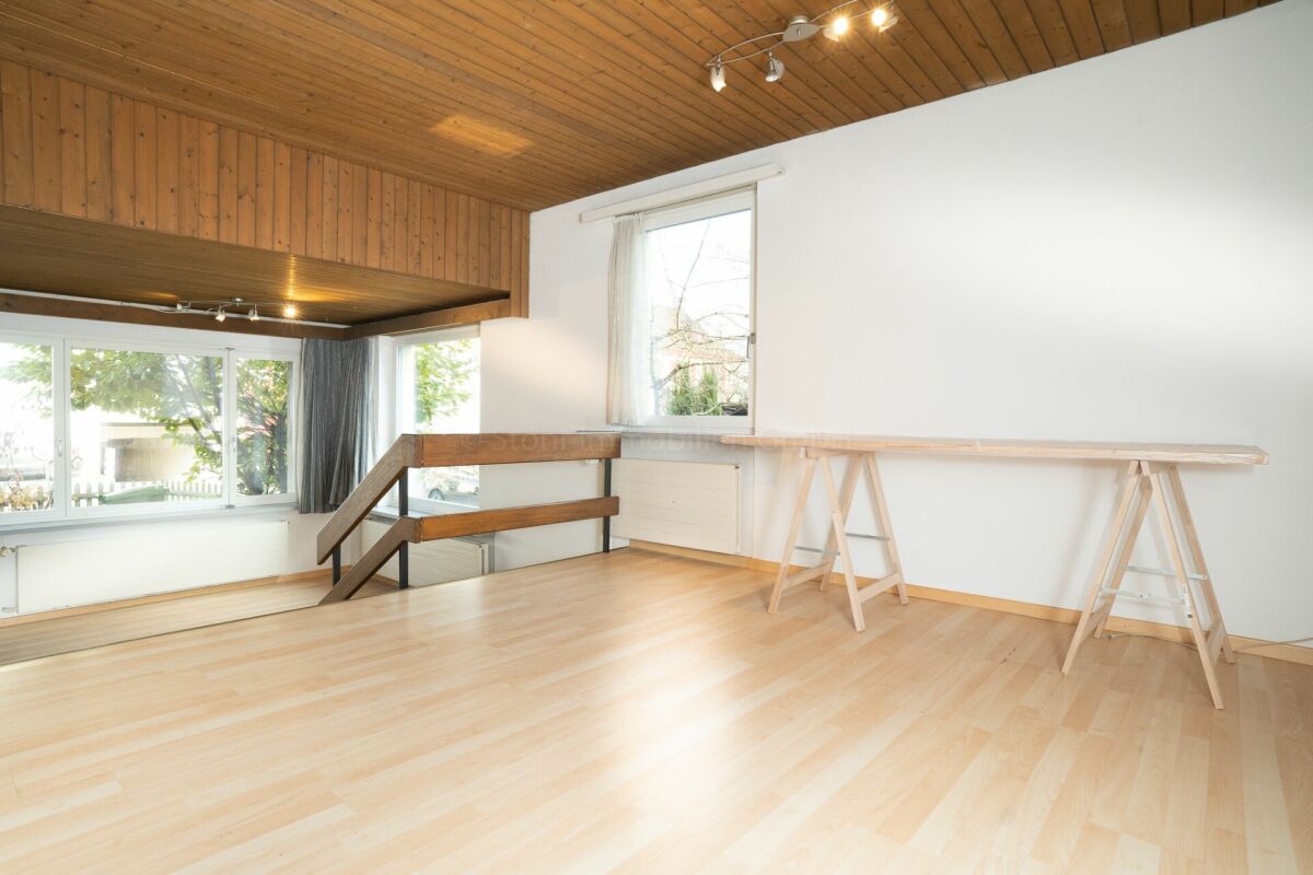 Heller Wohnraum mit Holzdecke und Treppe