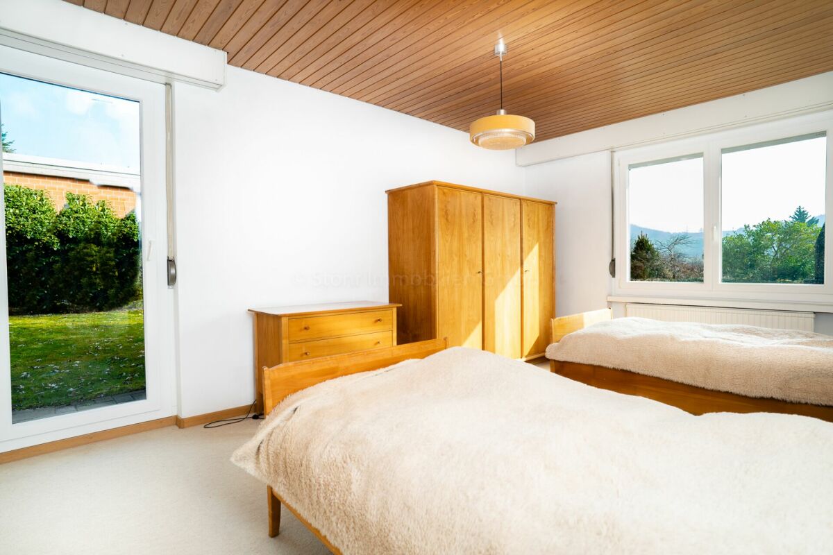 Schlafzimmer mit Holzdecke und Gartenblick