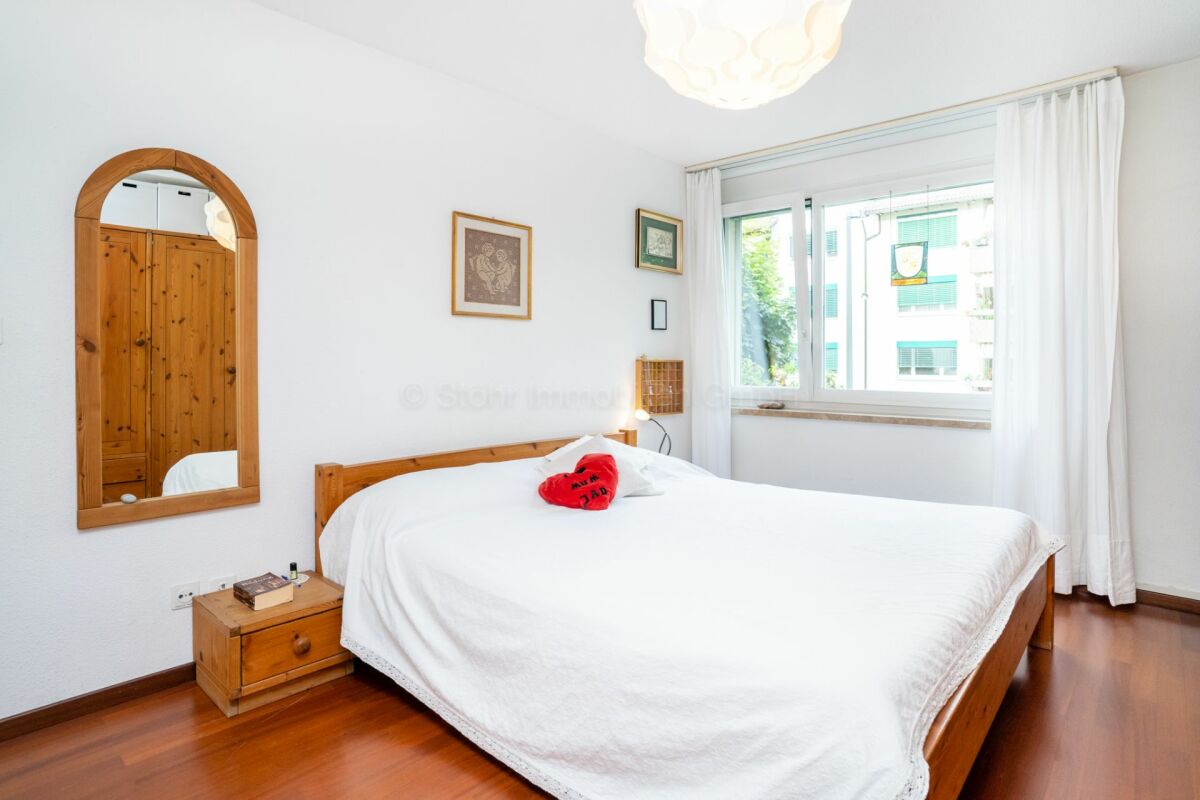 Helles Schlafzimmer mit Holzbetten und Fensterblick