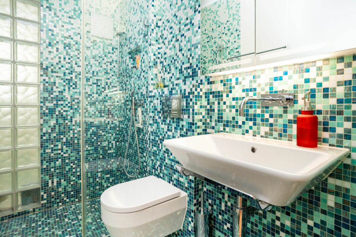 Modernes Badezimmer mit Mosaikfliesen und Glasdusche