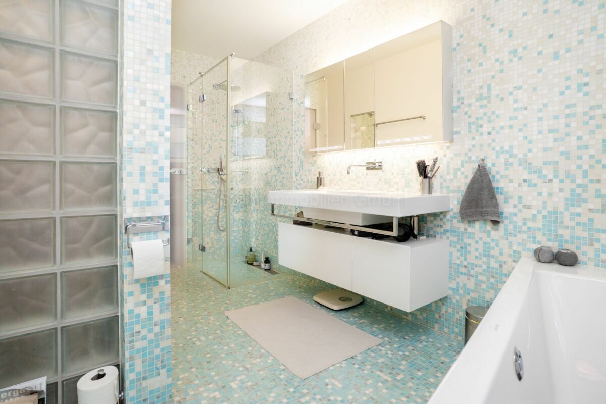Modernes Badezimmer mit Mosaikfliesen und Glasdusche