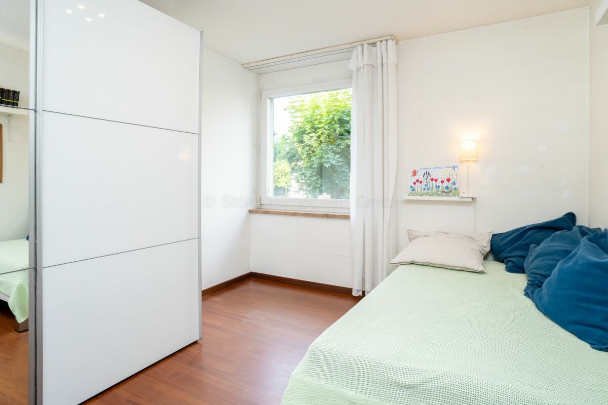 Helles Schlafzimmer mit Bett und Schrank