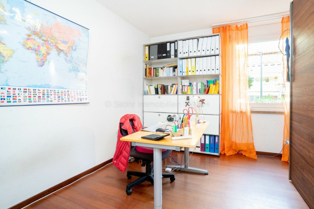 Arbeitszimmer mit Schreibtisch und Regal