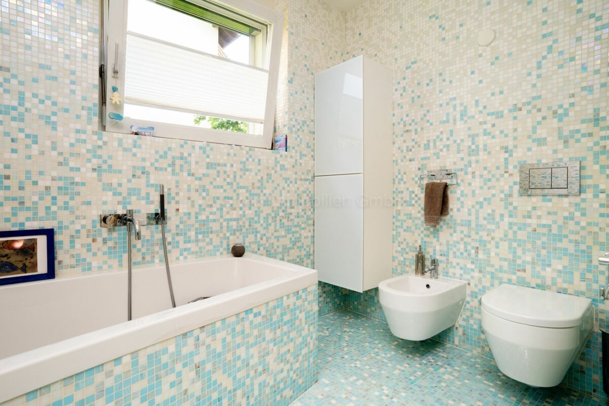 Bunt gefliestes Badezimmer mit Badewanne, Bidet und WC