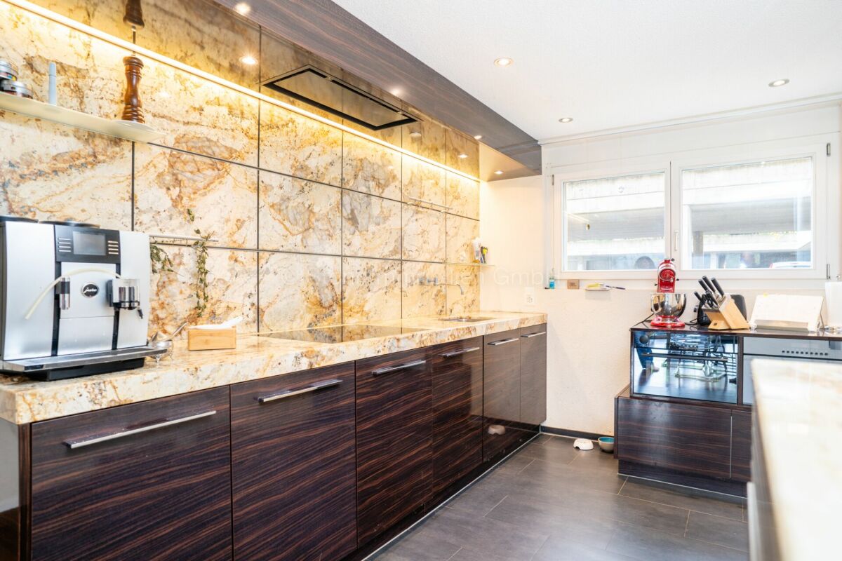 Moderne Küche mit Natursteinoptik und dunklen Fronten
