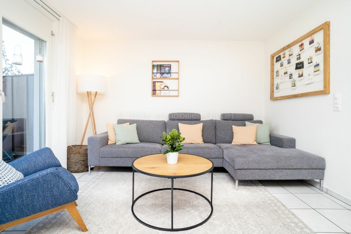 Helles Wohnzimmer mit Ecksofa und Balkontür