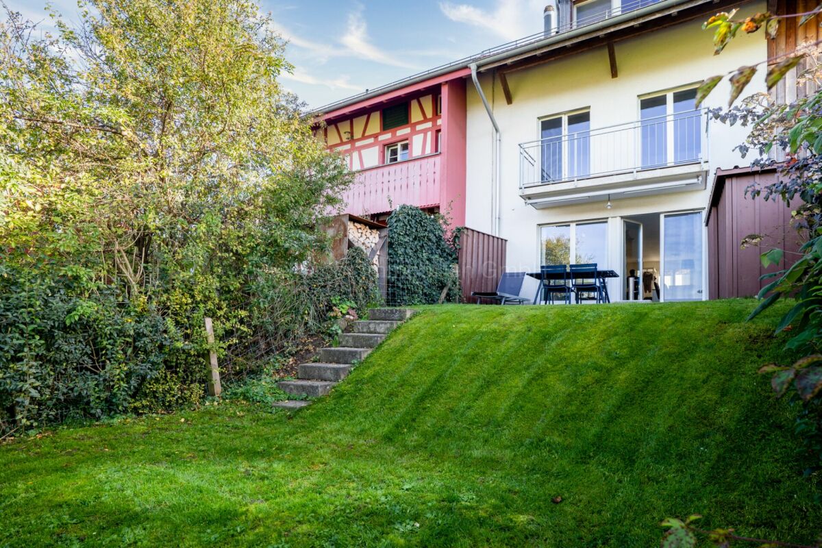 Gartenansicht eines Wohnhauses mit Terrasse und Balkon