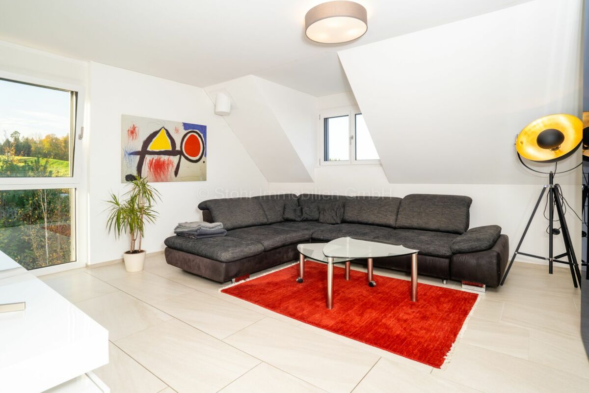 Helles Dachgeschoss-Wohnzimmer mit Ecksofa und großen Fenstern
