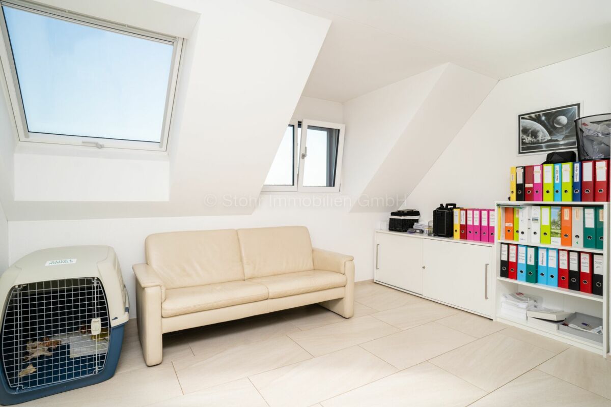 Helles Dachzimmer mit Sofa und Aktenregal