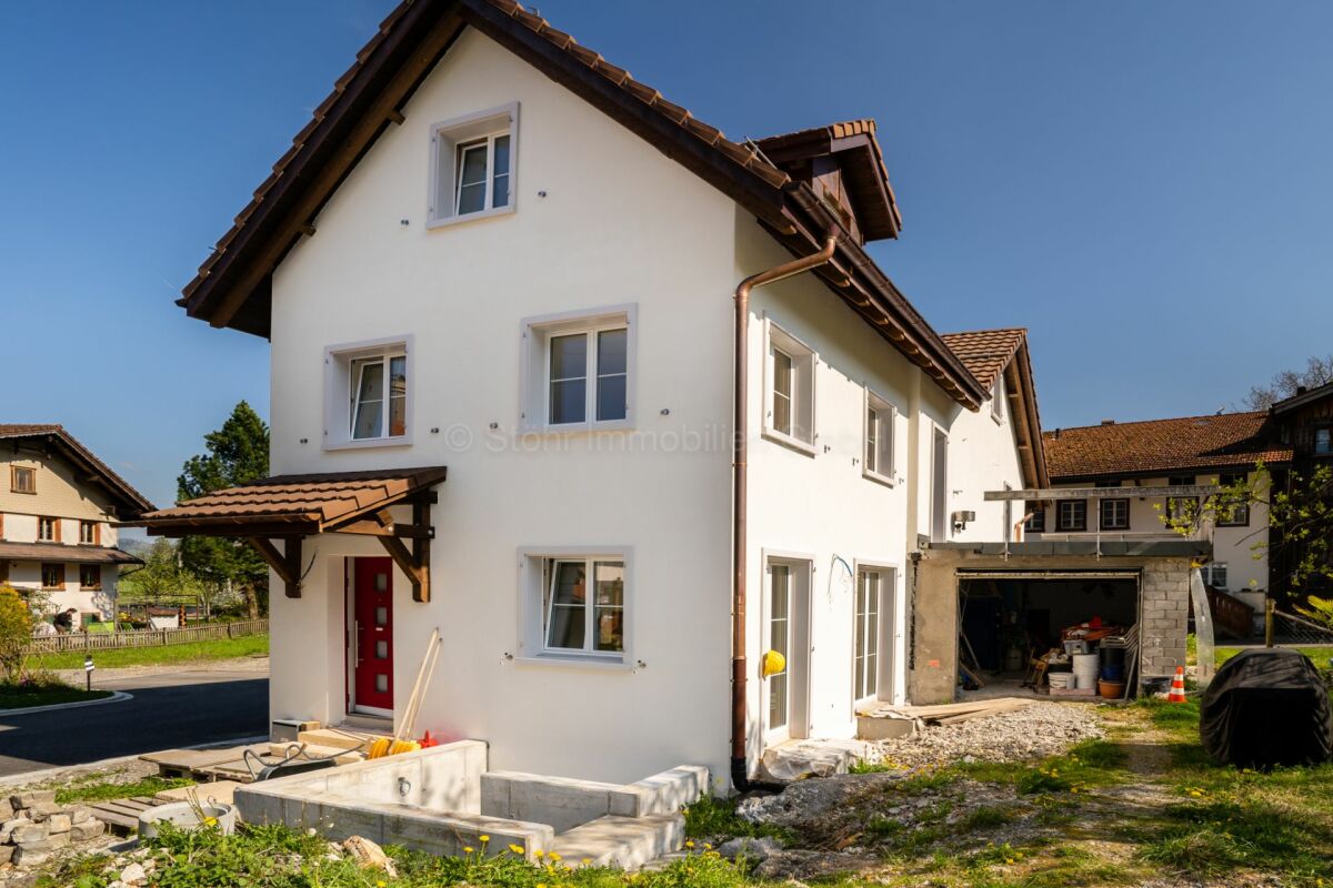 Außenansicht eines neueren Wohnhauses mit Gartenbereich und Nebengebäude